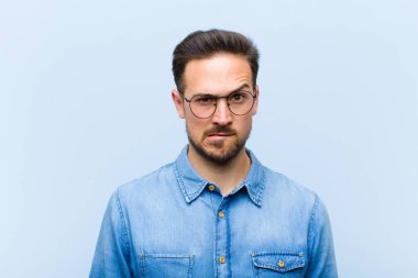 Genç yakışıklı adam kendini cahil, kafası karışmış ve hangi seçeneği seçeceği konusunda kararsız hissediyor, sorunu çözmeye çalışıyor.