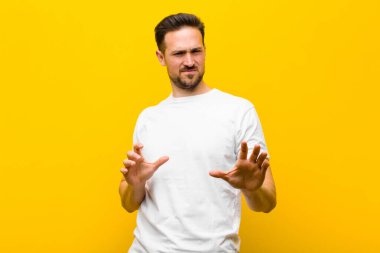 Genç yakışıklı adam tiksiniyor ve midesi bulanıyor. Pis kokan ya da kokan bir şeyden kaçıyor. Turuncu duvara karşı iğrenç diyor.