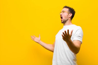 Genç yakışıklı bir adam opera yapıyor ya da konserde şarkı söylüyor. Romantik, sanatsal ve turuncu duvara karşı tutkulu hissediyor.