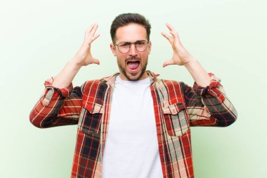 Genç yakışıklı adam elleri havada bağırıyor, öfkeli, sinirli, stresli ve üzgün hissediyor.