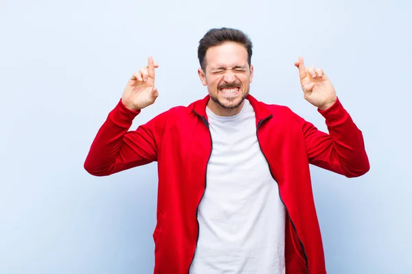 Jovem Homem Bonito Esportes Monitor Sentindo Nervoso Esperançoso Cruzando Dedos — Fotografia de Stock