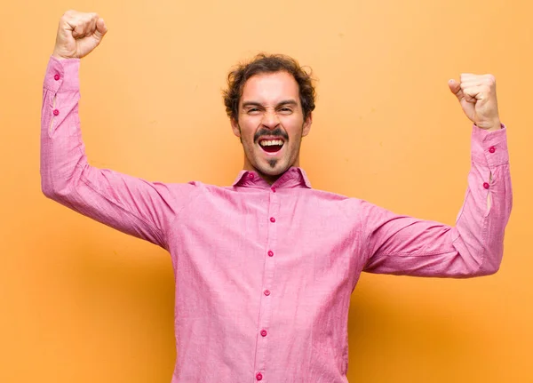 Joven Hombre Guapo Gritando Triunfalmente Pareciendo Emocionado Feliz Sorprendido Ganador —  Fotos de Stock