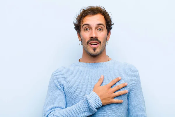 Joven Hombre Guapo Sintiéndose Sorprendido Sorprendido Sonriendo Tomando Mano Corazón — Foto de Stock