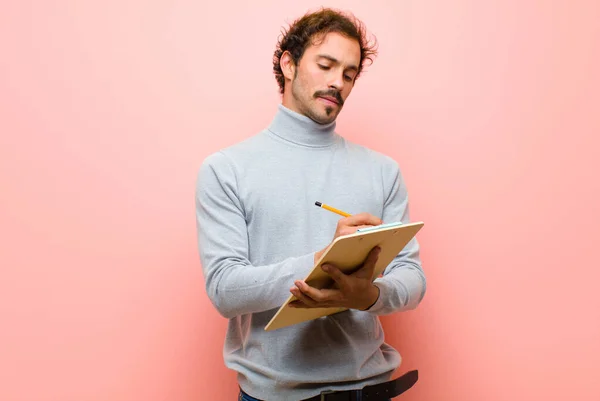 Jonge Knappe Man Met Een Vel Papier Tegen Roze Platte — Stockfoto