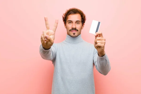 Young Handsome Man Credit Card Pink Flat Wall — Stock Photo, Image