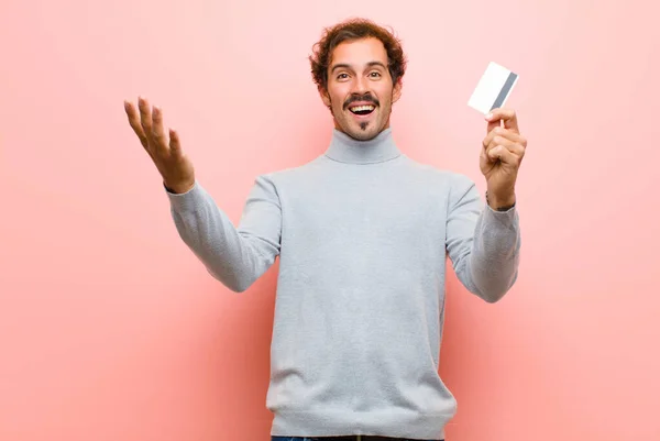 Young Handsome Man Credit Card Pink Flat Wall — Stock Photo, Image