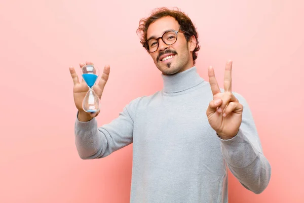 Joven Hombre Guapo Con Temporizador Reloj Arena Contra Pared Plana —  Fotos de Stock