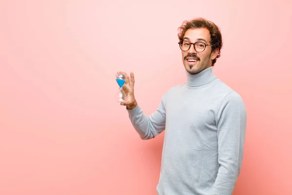 Joven Hombre Guapo Con Temporizador Reloj Arena Contra Pared Plana —  Fotos de Stock