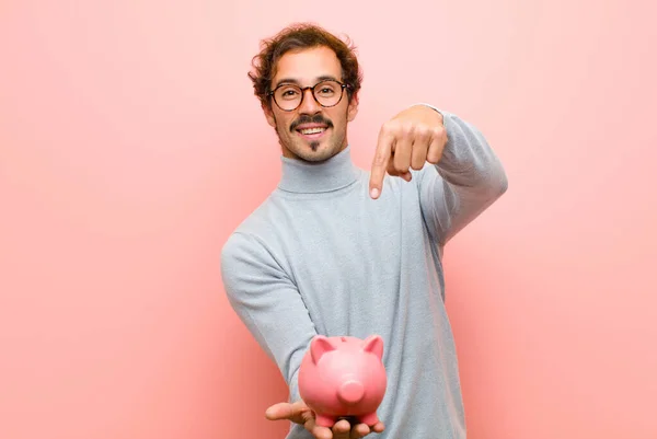 Jovem Bonito Homem Com Porquinho Banco Contra Rosa Parede Plana — Fotografia de Stock