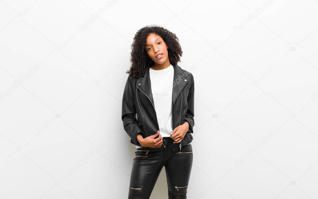 young pretty black woman wearing a leather jacket against white wall