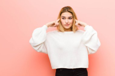 Genç, güzel sarışın kadın konsantre olmuş ve bir fikir üzerinde kafa yoruyor. Pembe düz duvara karşı bir meydan okuma ya da soruna bir çözüm hayal ediyor.