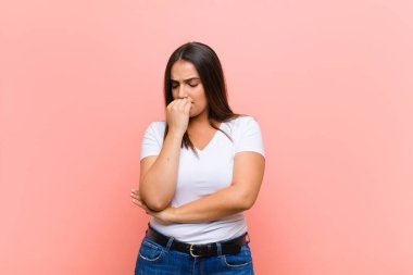 Genç ve güzel İspanyol kadın şaşkın ve şaşkın hissediyor. Deli, deli ya da pembe duvara karşı aklını kaçırmış olduğunu gösteriyor.