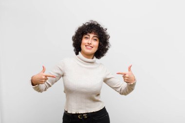 Genç, güzel afro kadın gururlu, kibirli, mutlu, şaşırmış ve tatmin olmuş görünüyor, kendini gösteriyor, kendini kazanan gibi hissediyor.