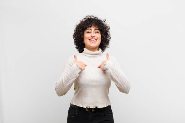 Genç, güzel afro kadın mutlu, şaşırmış ve gururlu hissediyor, heyecanlı ve şaşkın bir bakışla kendini işaret ediyor.