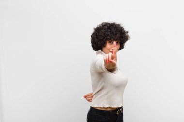 Genç, güzel afro kadın gururla gülümsüyor ve gururla bir numaralı pozunu veriyor, kendini lider gibi hissediyor.