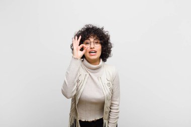 Genç, güzel afro kadın kendini başarılı ve tatmin olmuş hissediyor, ağzı açık gülümsüyor, elle imza atıyor.