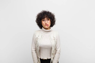 Genç, güzel afro bir kadın kafası karışmış ve kafası karışmış görünüyor. Sinirli bir hareketle dudağını ısırıyor. Sorunun cevabını bilmiyor.