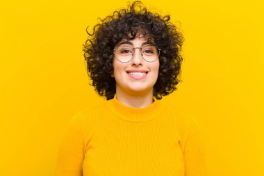 Genç, güzel afro kadın mutlu ve şapşal görünüyor. Geniş, eğlenceli, deli gülüşü ve gözleri açık.