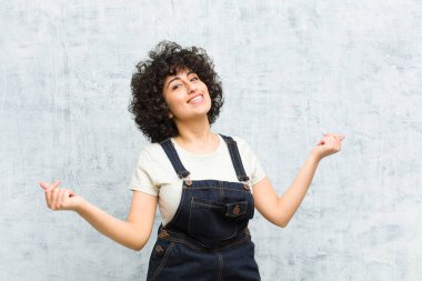 Genç, güzel afro kadın gülümsüyor, kaygısız hissediyor, rahat ve mutlu, dans ediyor ve müzik dinliyor, bir partide eğleniyor.