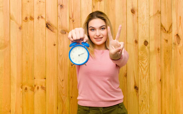 Young Pretty Blonde Woman Alarm Clock Wood Wall — Stock Photo, Image