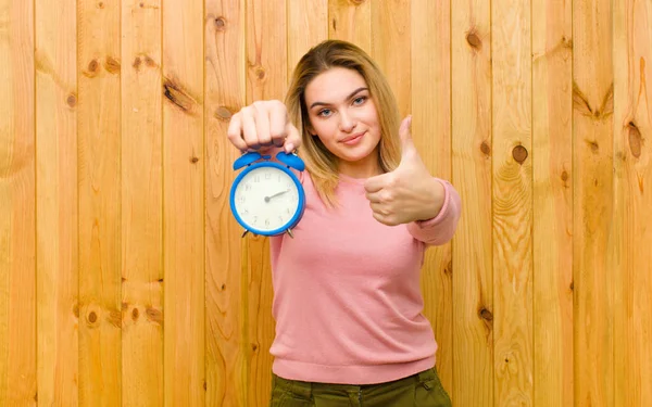 Joven Mujer Rubia Bonita Con Reloj Despertador Contra Pared Madera — Foto de Stock