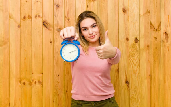 Ung Söt Blond Kvinna Med Väckarklocka Mot Trävägg — Stockfoto