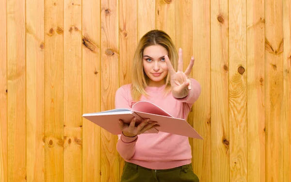 Junge Hübsche Blonde Frau Mit Büchern Gegen Holzwand — Stockfoto