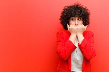 Genç, güzel afro kadın endişeli, stresli ve korkmuş görünüyor, tırnaklarını yiyor ve yanal fotokopi alanı arıyor.