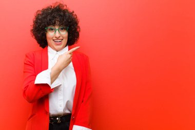 Genç, güzel, afro bir kadın heyecanlı ve şaşırmış görünüyor.