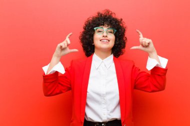 Genç, güzel afro bir kadın iki eliyle kendi gülümsemesini çiziyor, olumlu ve mutlu görünüyor, sağIık kavramı.