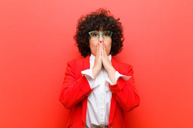 Genç, güzel bir afro kadın endişeli, üzgün ve korkmuş hissediyor, elleriyle ağzını kapatıyor, endişeli ve berbat görünüyor.