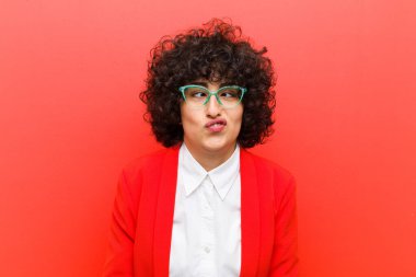 Genç, güzel, afro bir kadın şapşal ve komik görünüyor, şaşı bir ifadeyle, şakalaşıyor ve oynaşıyor.