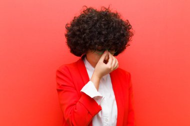 Genç, güzel afro kadın stresli, mutsuz ve hayal kırıklığına uğramış, dokunaklı alın ve şiddetli baş ağrısı çeken.