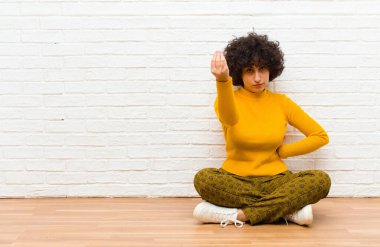 Genç, güzel afro kadın kapiş ya da para hareketi yapıyor, sana borçlarını ödemeni söylüyor! Yerde oturuyor.