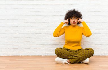 Genç, güzel afro kadın konsantre olmuş ve bir fikir üzerinde kafa yoruyor, bir meydan okumaya ya da yerde oturan bir soruna çözüm hayal ediyor.