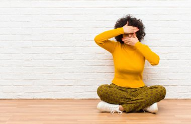 Genç ve güzel afro kadın kameraya hayır diyen iki eliyle yüzünü kapatıyor! Fotoğrafları reddetmek ya da yerde oturmayı yasaklamak