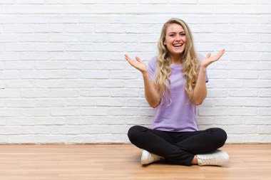 Genç sarışın güzel kadın mutlu, heyecanlı, şaşırmış ya da şok olmuş hissediyor, gülümsüyor ve hayrete düşüyor.