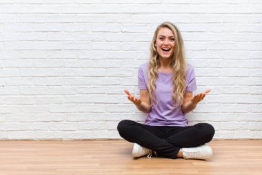 Genç sarışın, güzel bir kadın ağzı açık ve şaşkın, şok olmuş ve hayretler içinde inanılmaz bir sürprizle