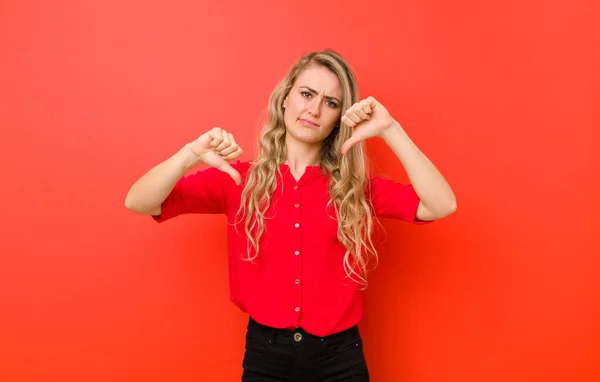 Jong Blond Vrouw Kijken Verdrietig Teleurgesteld Boos Tonen Duimen Naar — Stockfoto