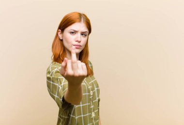 Genç kızıl saçlı güzel bir kadın kızgın, sinirli, isyankar ve agresif orta parmağını sallayarak karşılık veriyor.