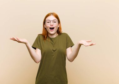 Genç kızıl saçlı güzel bir kadın ağzı açık ve şaşkın, şok olmuş ve hayretler içinde inanılmaz bir sürprizle