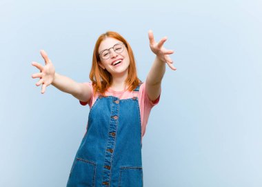 Genç kızıl saçlı güzel bir kadın neşeyle gülümsüyor sıcak, dostça, sevgi dolu bir kucaklama yapıyor, mutlu ve sevimli hissediyor.