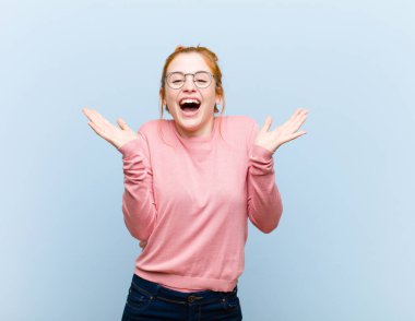 Genç kızıl saçlı güzel kadın mutlu ve heyecanlı görünüyor. Beklenmedik bir sürprizle şoke oldu. İki eli de açık.