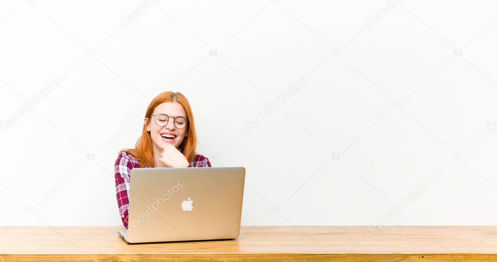 young red head pretty woman in front of a wooden table