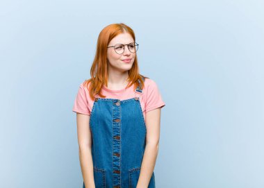 Genç kızıl saçlı güzel kadın endişeli, stresli, endişeli ve korkmuş görünüyor, panikliyor ve dişlerini sıkıyor