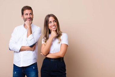 Genç ve güzel bir çift bej düz duvara karşı