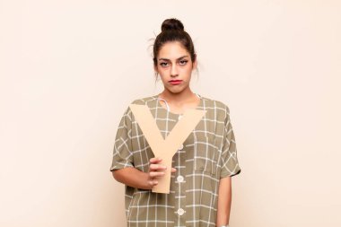 Genç, güzel bir kadın üzgün, depresif, mutsuz, bir kelime ya da cümle oluşturmak için alfabenin Y harfini tutuyor..