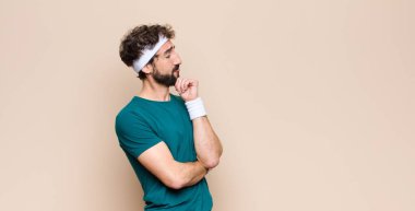 Genç sporcu düz duvara karşı bir konsept ifade ediyor.