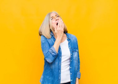 Yaşlı ya da orta yaşlı güzel bir kadın sabahın erken saatlerinde uyanıyor, uykulu, yorgun ve sıkkın görünüyor.