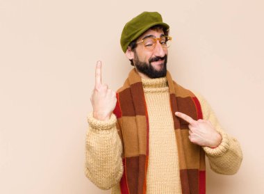 Genç havalı sakallı adam gururlu ve şaşırmış hissediyor. Kendine güvenerek kendini bir numara gibi hissediyor.